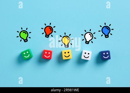 Brainstorming and generating different creative ideas. Idea variation and teamwork. Problem solving. Colorful cubes with happy face emoticons and ligh Stock Photo