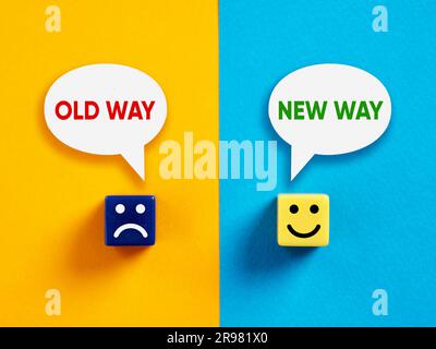 New way versus old way. Change, transformation or resistance to change in business or life. Cubes with happy and unhappy faces with the words new way Stock Photo