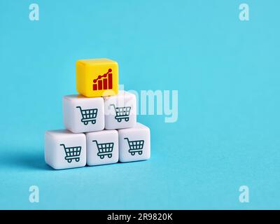 Increase in sales volume and business growth. Shopping cart and ascending graph on cubes. Stock Photo