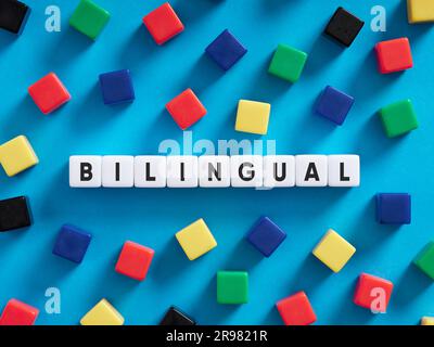 Bilingual education concept. Colorful cubes on blue background with the word bilingual. Stock Photo
