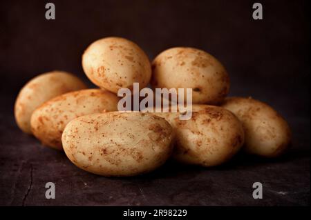 Raw potatoes on black background Stock Photo