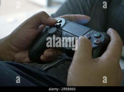 Jakarta, Indonesia - June 20, 2023 : close up of hand holding playstation stick Stock Photo