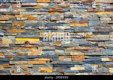 Background from a wall made of small stone tiles Stock Photo