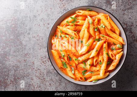 Delicious plate of italian food pink sauce pasta closeup on the bowl on the table. Horizontal top view from above Stock Photo