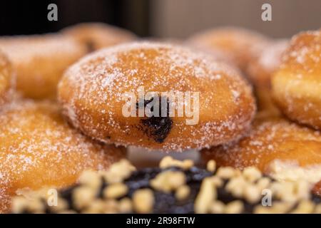 A stack of freshly-baked donuts arranged in neat rows on top of each other creating a delicious display Stock Photo