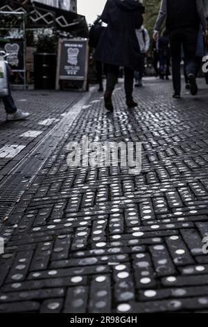 THE HAGUE, NETHERLANDS - OCTOBER 7, 2021: Street art on the pavement made with coins from all over the world, The Hague, The Netherlands Stock Photo