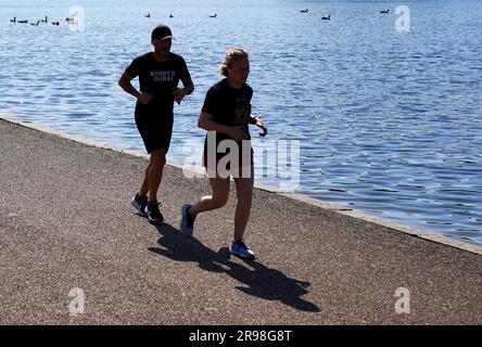 Visitors to Hyde Park, London, run alongside the Serpentine. Picture date: Sunday June 25, 2023. Stock Photo