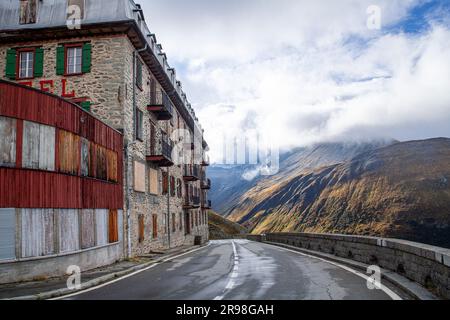 Mountain road in the Swiss Alps with old houses in the foreground Stock Photo
