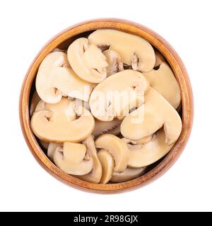 Canned sliced white champignon mushrooms, in a wooden bowl. Agaricus bisporus, also called common, button, cultivated or table mushroom. Stock Photo