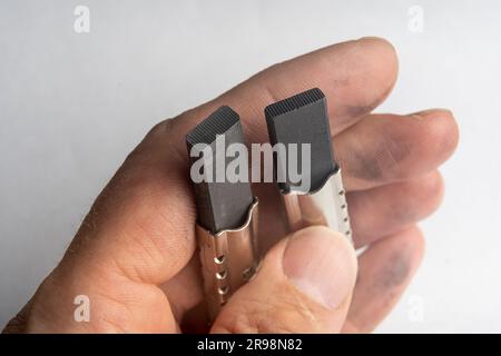 new electric brushes in the hand of a repairman. replacement of graphite sliding contacts in the electric motor of the washing machine. washing machin Stock Photo