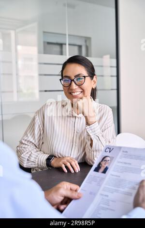 Smiling Asian woman candidate and hr manager holding cv during job interview. Stock Photo