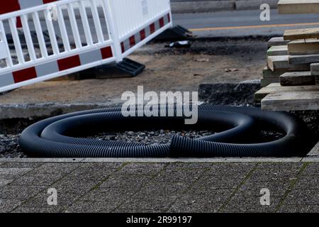 Black corrugated plastic tube laying on a construction site Stock Photo