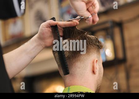 Back view of unrecognizable male making haircut to guy using scissors  against blurred interior of light bathroom at home Stock Photo - Alamy