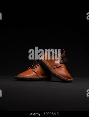 A pair of high-quality brown leather shoes in dark background. Stock Photo