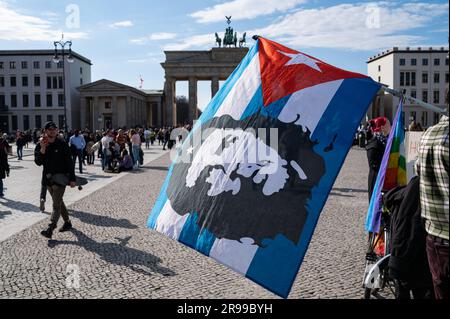 18.03.2023, Berlin, Germany, Europe - Participant of the alliance group Frente Unido (United front) carries a Cuban flag with the image of Che Guevara. Stock Photo