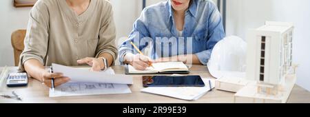 Engineering construction concept, Two female engineers is discussing construction and taking notes. Stock Photo