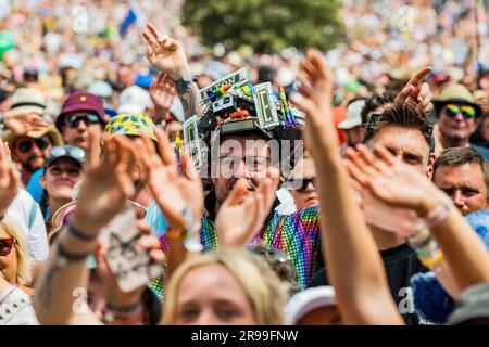 Glastonbury, UK. 25th June, 2023. Fans (many already in Elton John outfits incl Alex McGuire and his Elton tribute pyramid stage model hat) watch as Sophie Ellis-Bexter plays the Pyramid stage and includes a song as tribute to her husband, guitar player, as it is their wedding anniversary - unday at the 2023 Glastonbury Festival, Worthy Farm, Glastonbury. Credit: Guy Bell/Alamy Live News Stock Photo