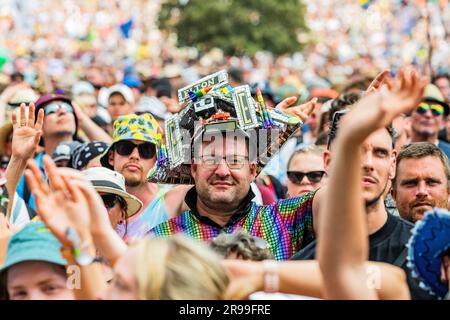 Glastonbury, UK. 25th June, 2023. Fans (many already in Elton John outfits incl Alex McGuire and his Elton tribute pyramid stage model hat) watch as Sophie Ellis-Bexter plays the Pyramid stage and includes a song as tribute to her husband, guitar player, as it is their wedding anniversary - unday at the 2023 Glastonbury Festival, Worthy Farm, Glastonbury. Credit: Guy Bell/Alamy Live News Stock Photo