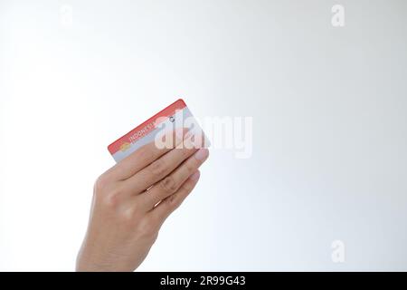 Surat Ijin Mengemudi or SIM C means Indonesian Driving License for a motorcycle held by a hand on isolated white background Stock Photo