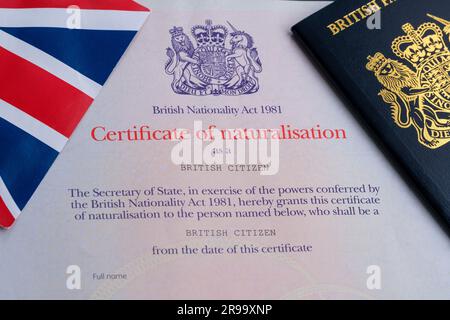 UK flag and passport top of authentic Citizenship certificate. Certificate of naturalisation as a British Citizen. Stafford, United Kingdom, June 25, Stock Photo