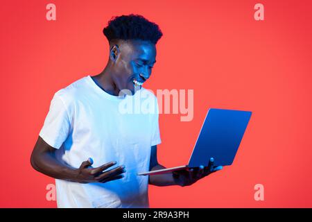 Happy young black man using modern computer laptop Stock Photo