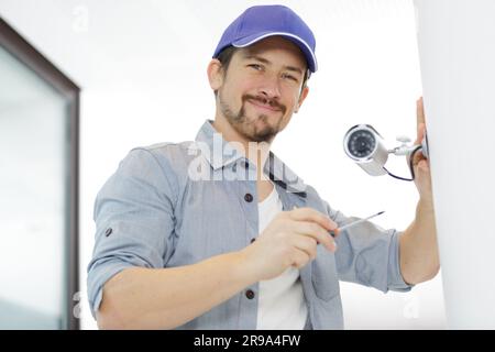 contractor installing surveillance cctv cameras in office Stock Photo