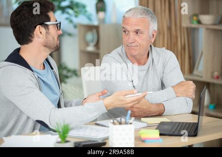 smiling senior employee discussing email with colleague Stock Photo