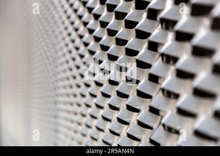 Dark gray perforated metal surface texture background with colored stripe light Stock Photo