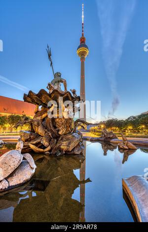 The TV Tower and the Neptune Fountain on Alexanderplatz in Berlin at dawn Stock Photo