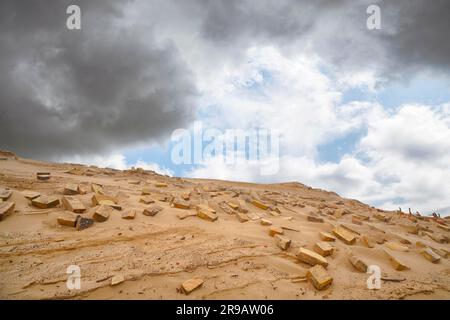 Bricks in the sand left remains of a building in the desert under a blue sky Stock Photo