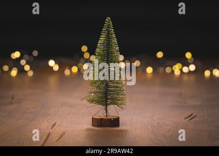 Christmas tree decoration on a wooden surface with golden bokeh lights in the background Stock Photo