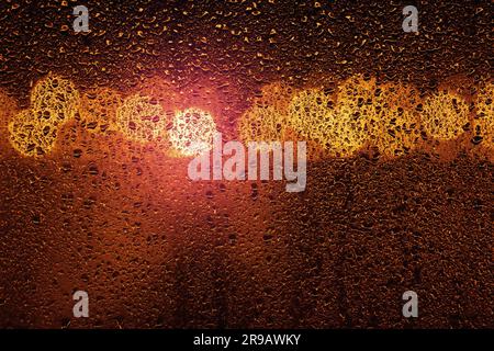 Rain on a window with big city bokeh lights in orange and violet colors Stock Photo