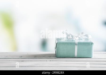 Blue gift box on a wooden table in bright light Stock Photo