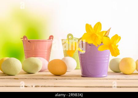 Easter eggs and flowerpots with daffodils on a wooden table Stock Photo