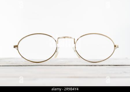 Eyeglasses on a wooden desk in bright environment Stock Photo