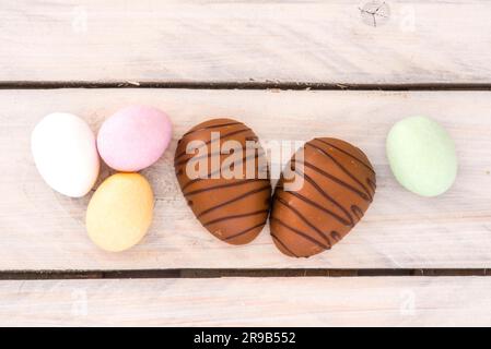 Easter candy eggs in various colors on a wooden table Stock Photo