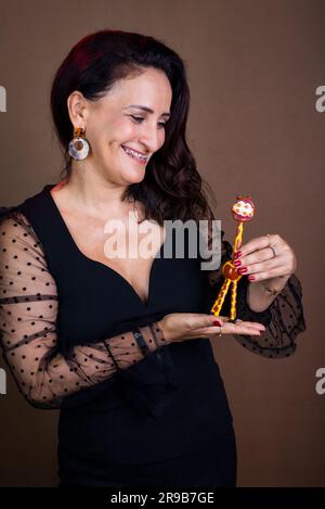 Coaching woman in black clothing holding the giraffe symbol of non-violent communication. Isolated on brown background. Stock Photo