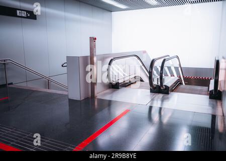Indoor shot, a modern ambiance. The predominantly grey environment is accentuated by a vibrant popping red line at the beginning and end of a moving s Stock Photo