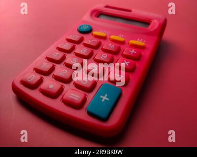 Closeup red calculator on a red background Stock Photo