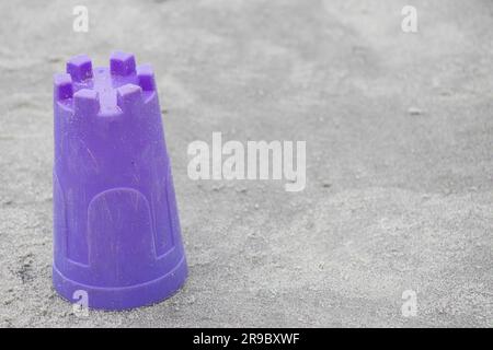 abandoned purple bucket on the sand at the beach, not being played with, copy space Stock Photo