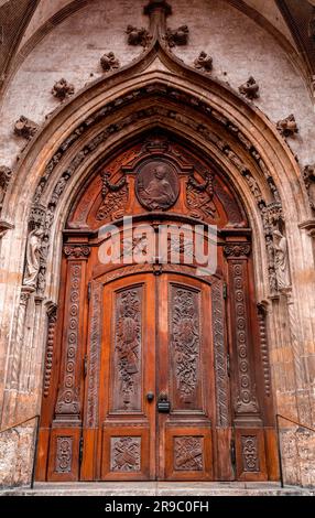 Munich, Germany - December 26, 2021: Historical wooden gate of Frauenkirche with rich carving ornaments, Munich, Germany. Stock Photo