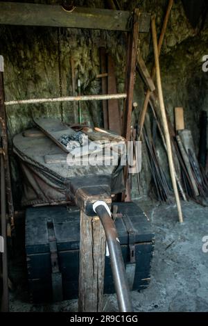 View of traditional blacksmith's shop for forging medieval iron, with furnace and an ancient bellows blower. Stock Photo