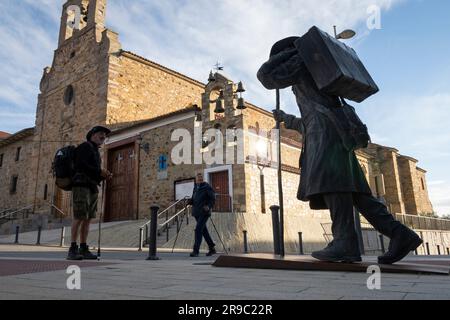 Pilgrims on the Camino Frances admire the statue of a pilgrim at the Albergue de peregrinos Siervas de María as they arrive in Astorga, Spain. This an Stock Photo
