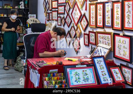 Sign writer and calligrapher working in shop at Stanley Market, Hong Kong, SAR, China Stock Photo