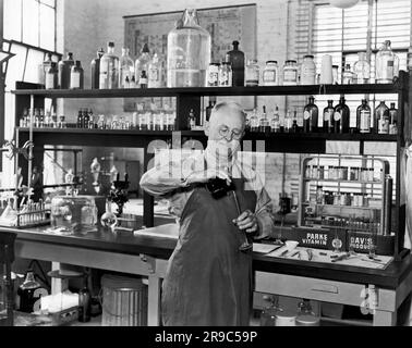 United States:  c.  1948 A chemist working in a laboratory with a Parke Davis Vitamin Products display on the table. Stock Photo