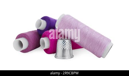 Thimble and spools of sewing thread isolated on white Stock Photo