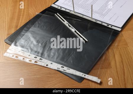 File folder with punched pockets on wooden table, closeup Stock Photo