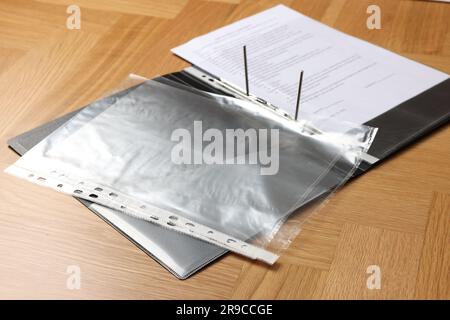 File folder with punched pockets on wooden table Stock Photo