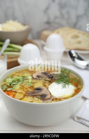 Delicious sauerkraut soup with mushrooms, dill and sour cream served on white table Stock Photo