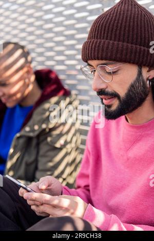 young man using mobile phone with friends Stock Photo